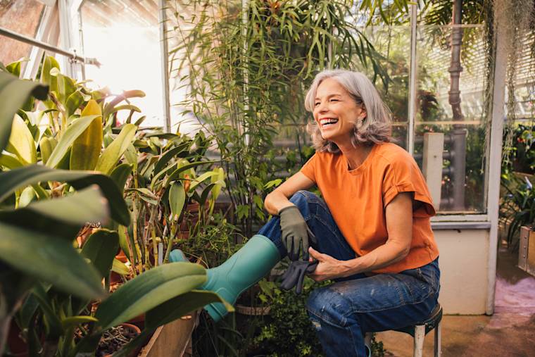 Person potting plants in a greenhouse.