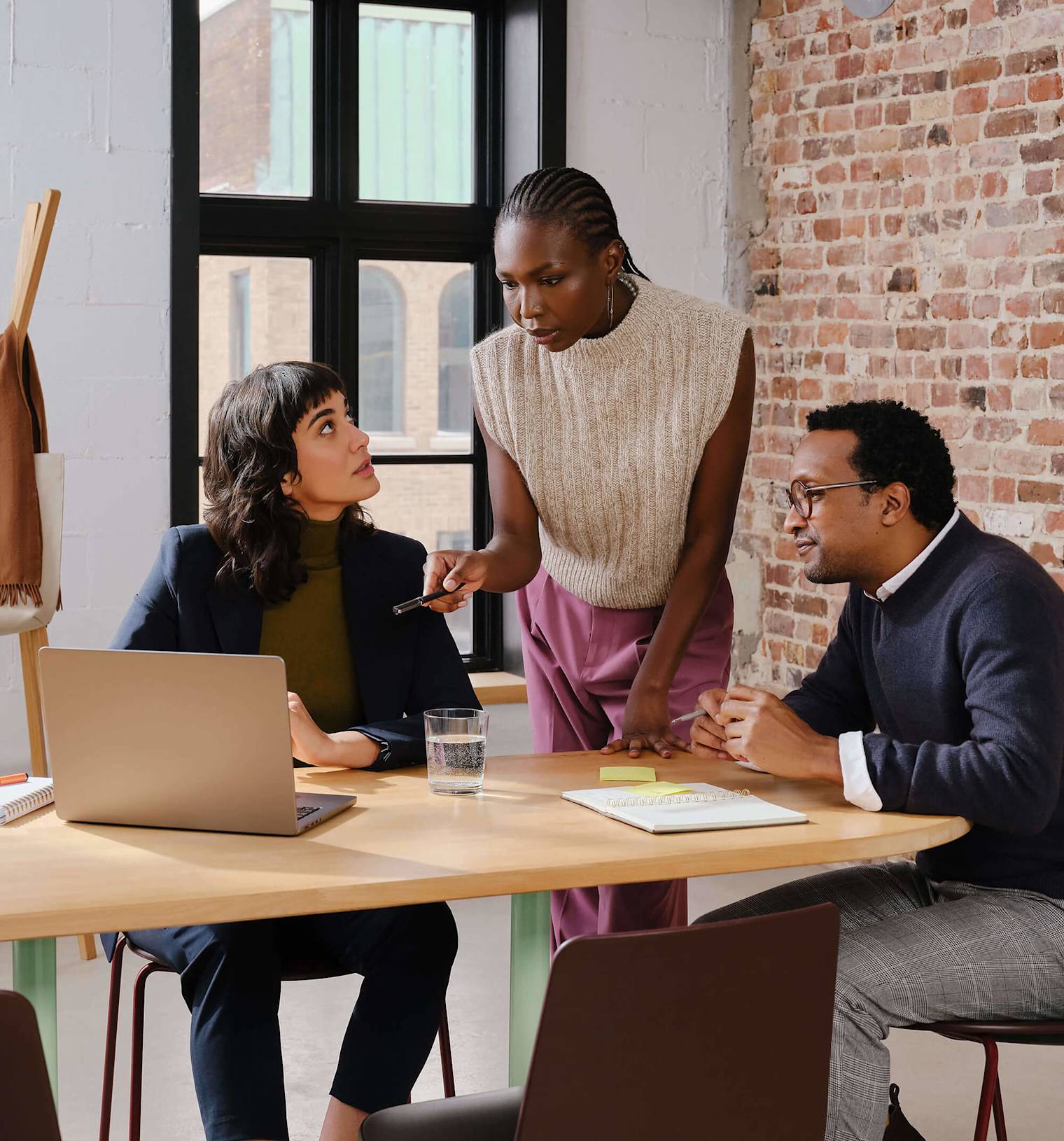 Three agency colleagues working together in a modern office while looking at their computer screen.