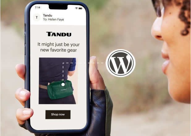 A person holding a smartphone displaying an ad for a green gear bag with text: "It might just be your new favorite gear. Shop now."