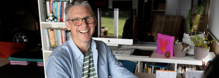 Smiling employee getting training at his home office